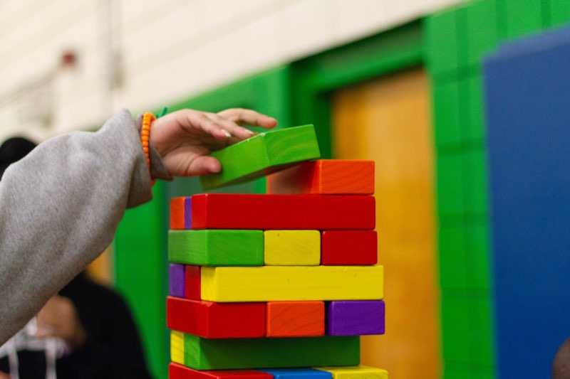 Main d'enfant empilant des blocs de bois