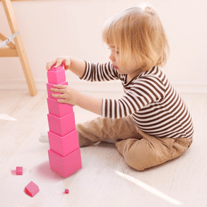 Un enfant qui empile les différents cubes.