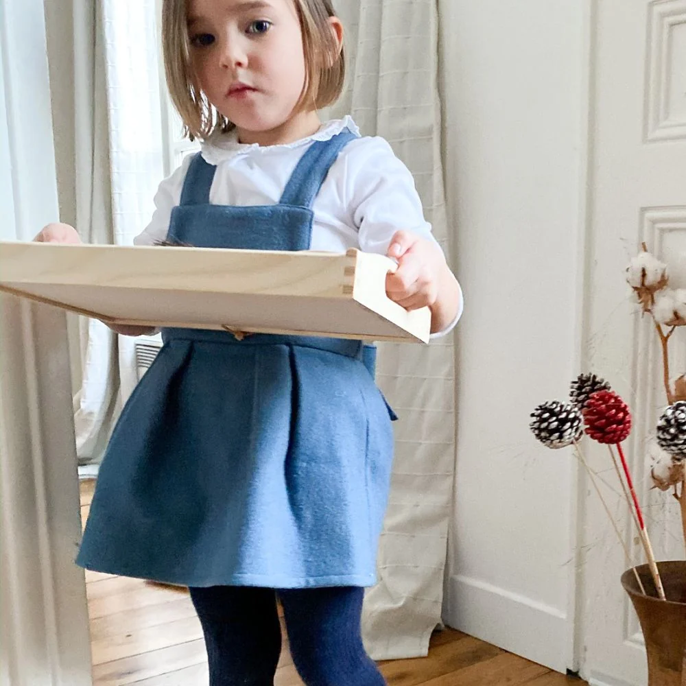 L'enfant qui porte son plateau afin de réaliser son activité en toute sérénité
